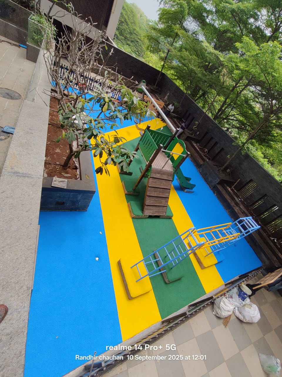 Blue and yellow EPDM wet pour surface laid in a terrace play area