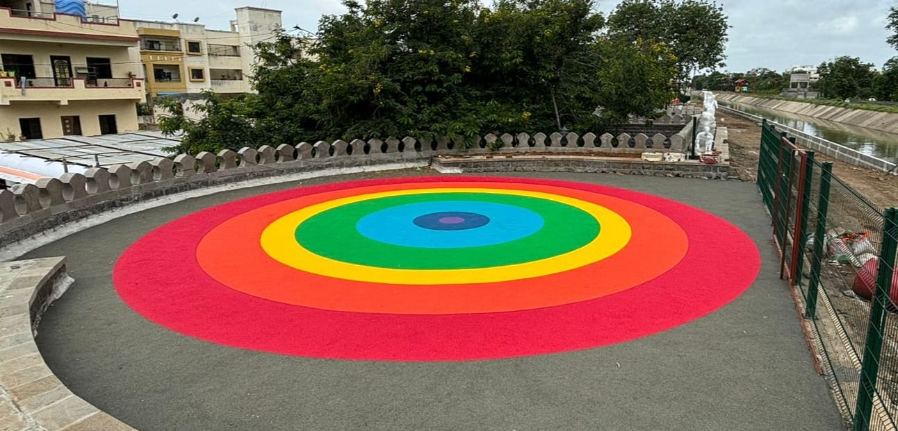 Concentric rainbow EPDM wet pour circle in an open recreational area