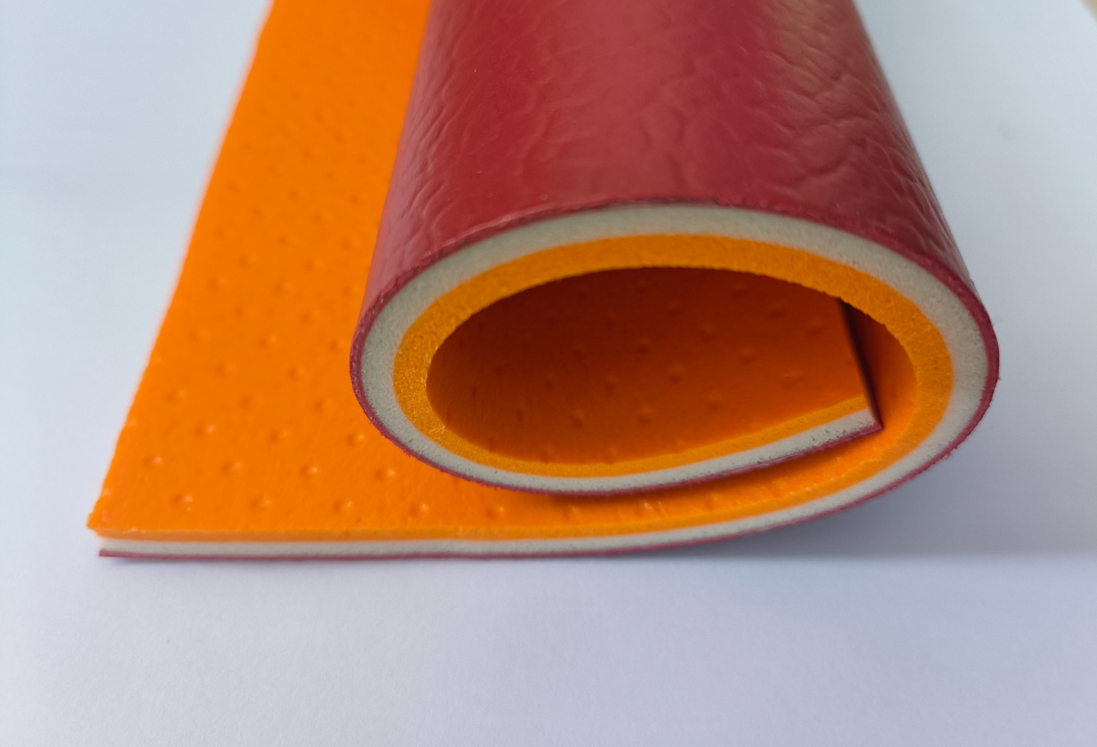 8 mm PVC vinyl roll cross-section in red showing wear layer and backing