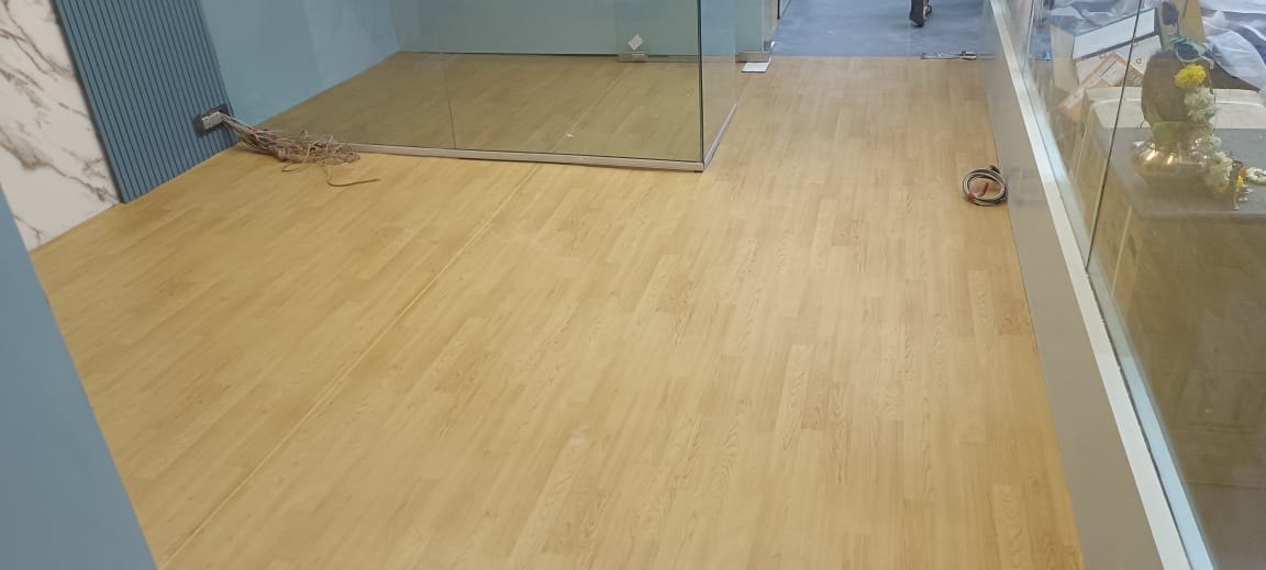 Oakwood finish PVC vinyl flooring beside a glazed studio wall