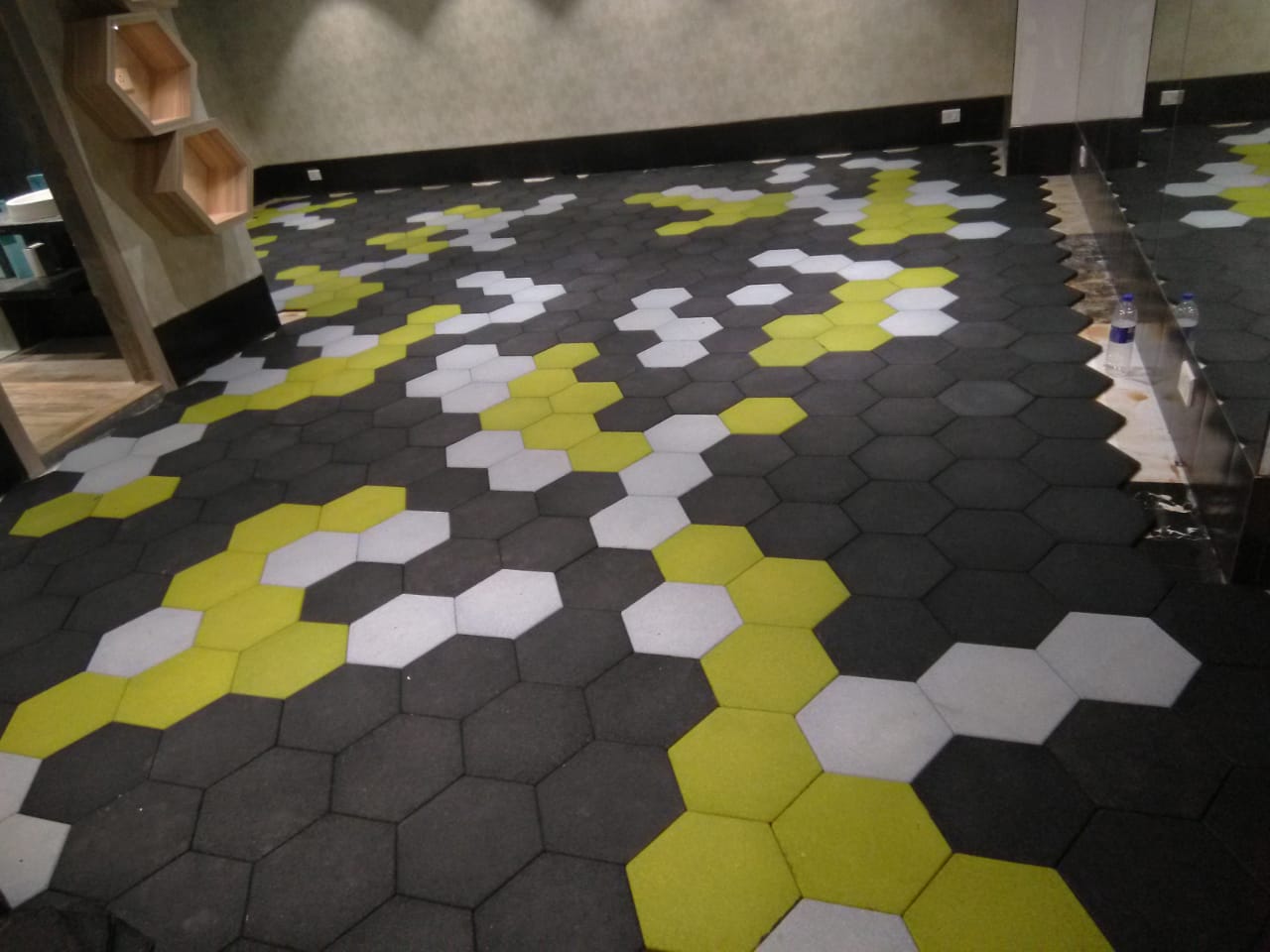 Tuffloor Hexa hexagonal rubber tiles in terracotta, metallic blue and silver grey laid across a training floor