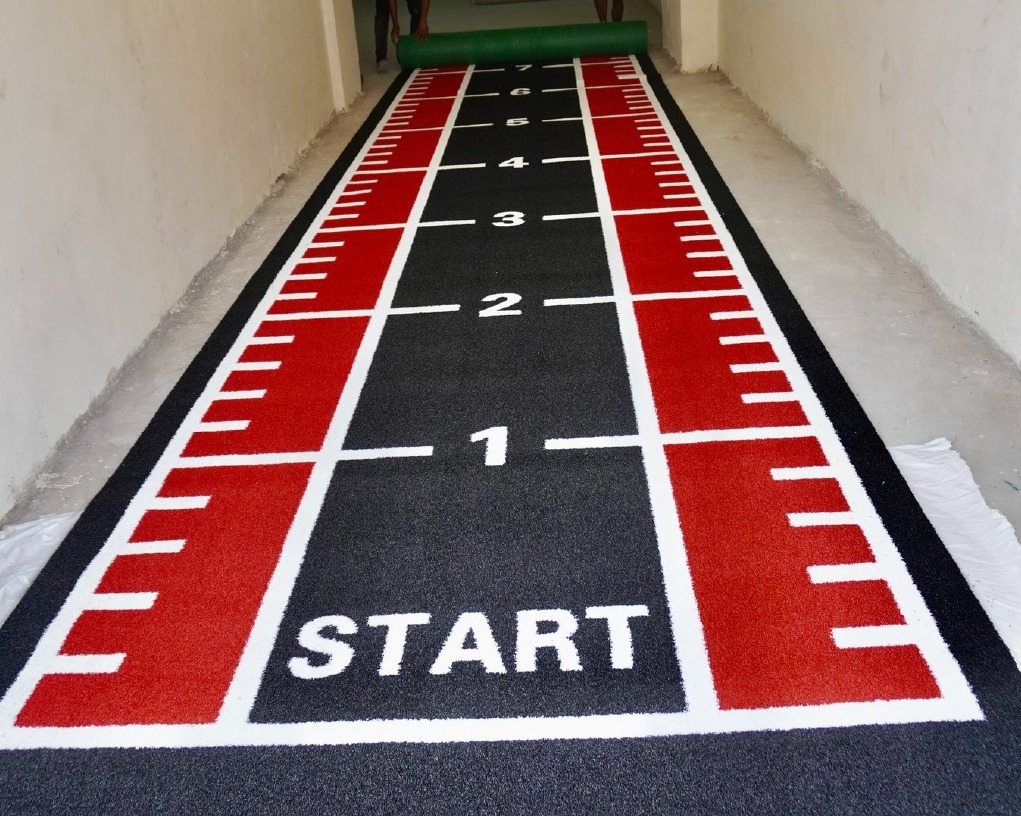 Astro Turf sled and sprint track in black and red with printed START markings and distance numbers
