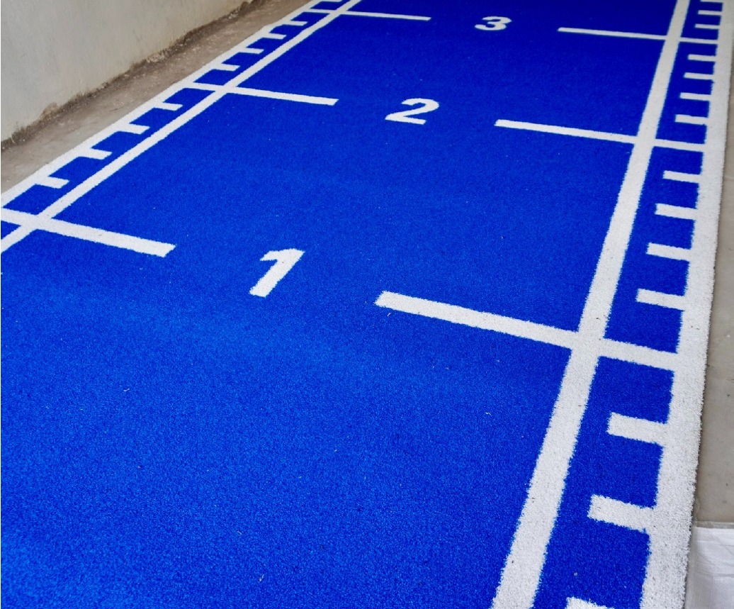 Blue Astro Turf sprint track with white distance markings