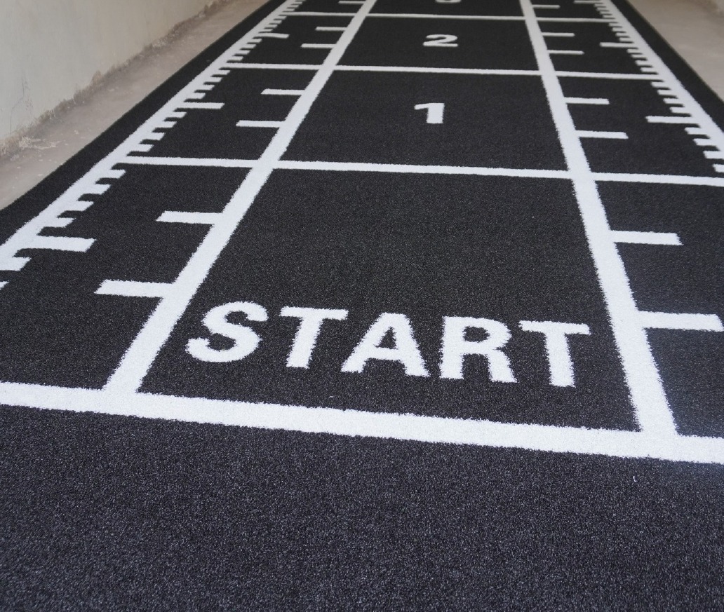 Dark grey Astro Turf gym track with START graphic