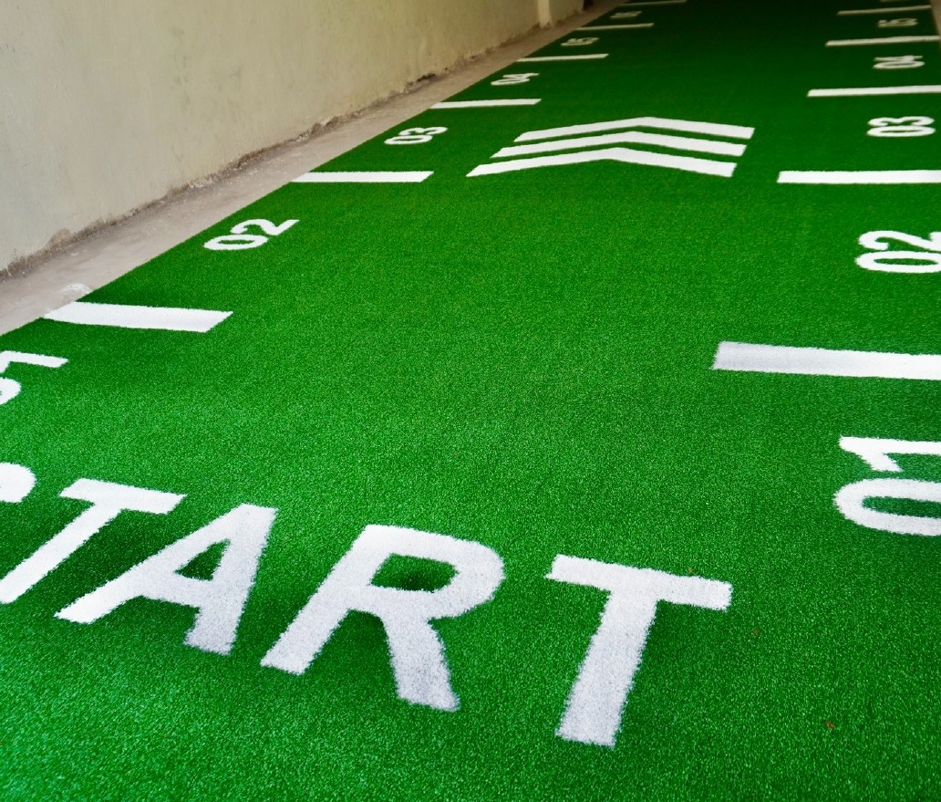 Close-up of green Astro Turf fibres with printed START lettering