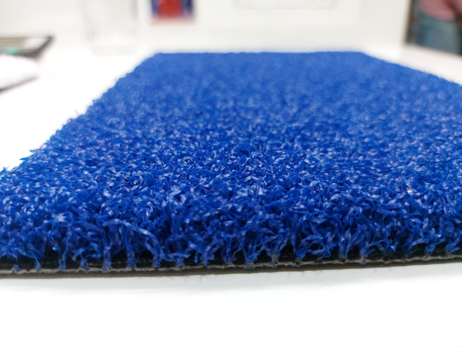 Blue multisports artificial grass sample showing pile and backing