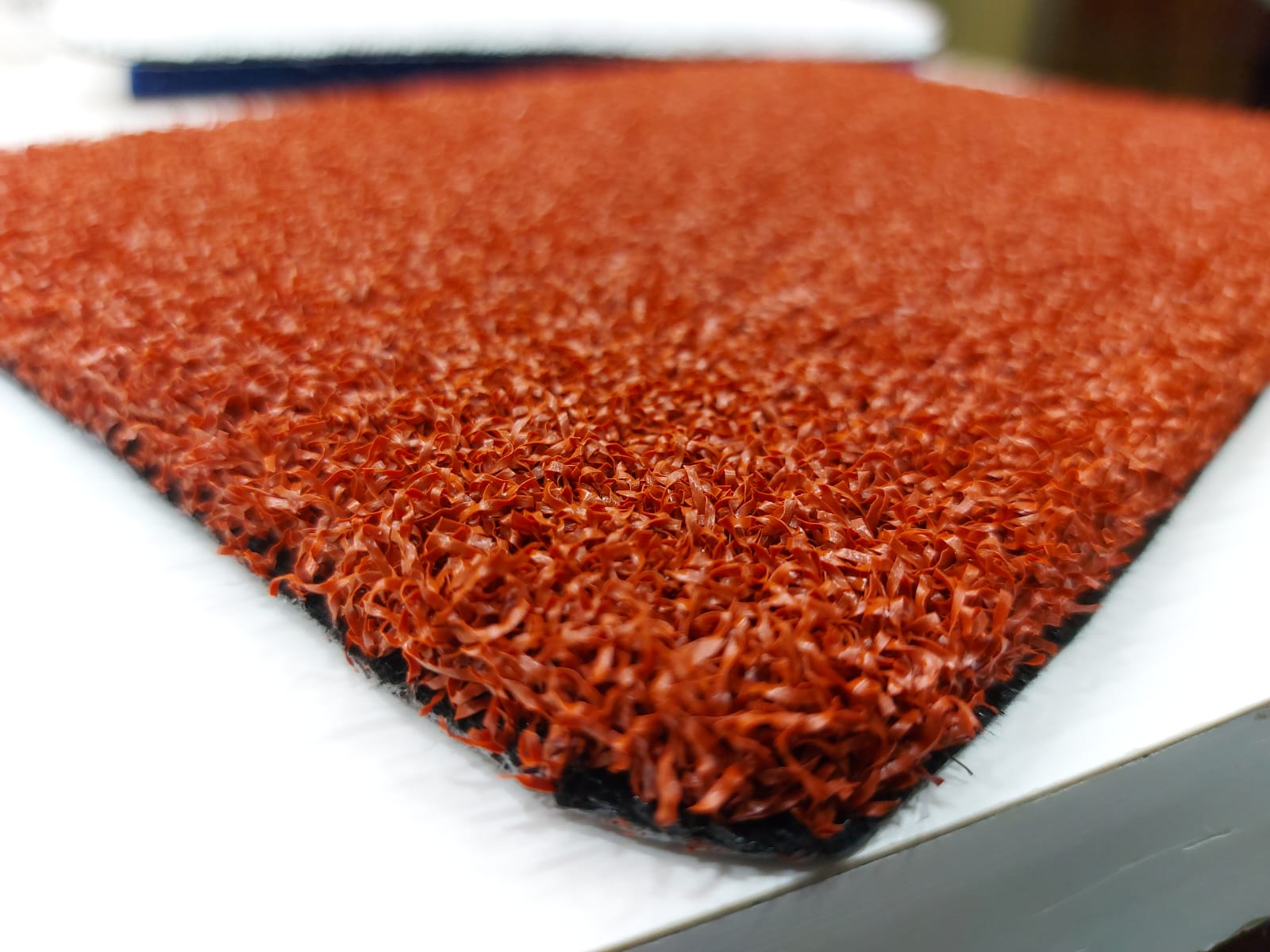 Terracotta multisports artificial grass sample showing pile texture